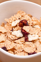 granola and fresh blueberries, in glass bowl over wood backgroun