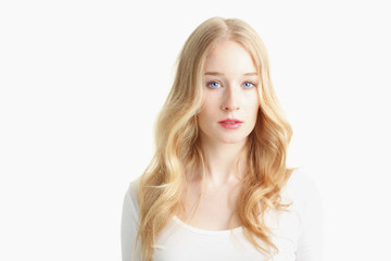 Naklejka premium Close-up of a beautiful young woman smiling on white background