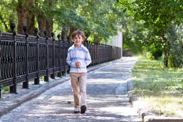 Fototapeta premium Little boy walking on a sunny street