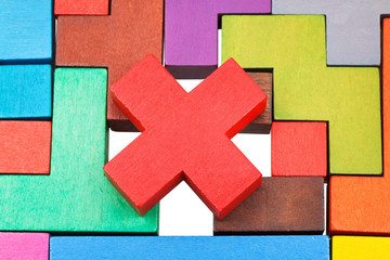 cross shaped piece on multicoloured puzzle