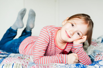 Beautiful little girl resting on a bed