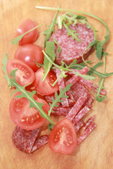Sausage and tomatoes on a cutting board.