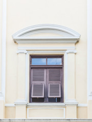 wooden window with shutters open on light yellow wall