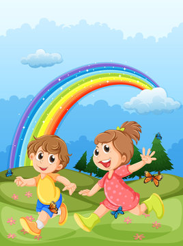 Kids playing at the hilltop with a rainbow in the sky