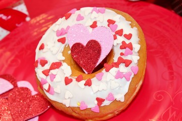 White frosted donut with heart sprinkles