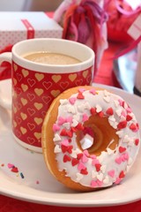 Coffee and a glazed donut with sprinkles