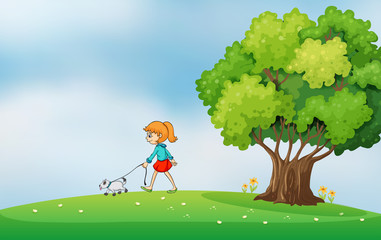 A girl walking with her dog at the hilltop