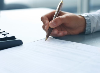 Businesswoman sitting at office desk signing a contract