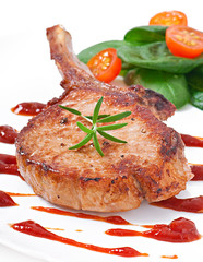Juicy grilled pork fillet steak with greens