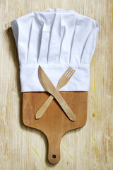 Fototapeta na wymiar Chef hat and empty cutting board abstract food background