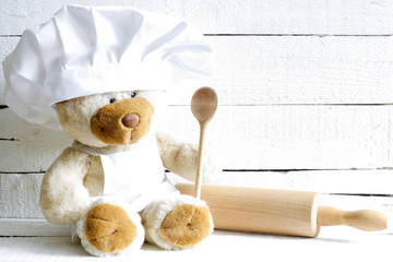 Teddy bear in chef hat with spoon abstract food background