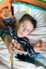 Sick child in bed with teddy bear