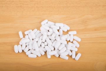 Fototapeta na wymiar White Pills on Wood Table