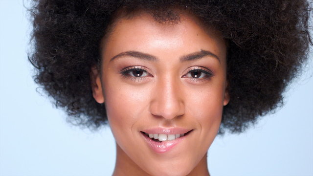 Beautiful sexy sensual young African American woman biting her lip, close up of her face on grey