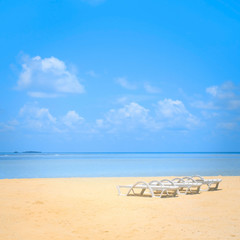Beach chairs on the white sand beach with beautiful cloudy