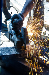 Worker grinding a metal plate.