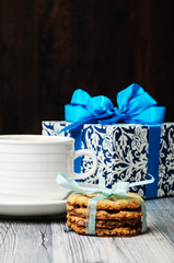 A blue box and a white cup with cookies