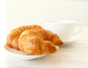 Two croissants and a clean white cup