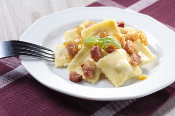 Portion of ravioli with onion and bacon