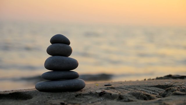 Stacked stones on the beach at sunset