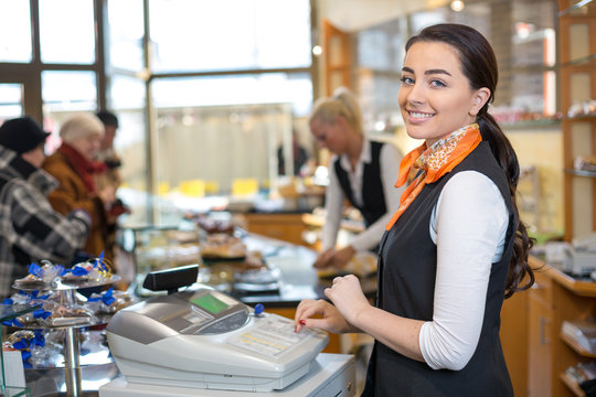 Shopkeeper and saleswoman at cash register or cash desk