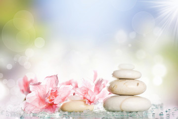 Fototapeta na wymiar Spa treatment massage stones and pink flower