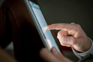 close up of finger touching tablet device