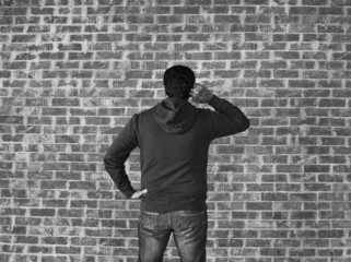 Young man thinking against wall ,black and white