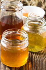 Honey in a glass jars on a wooden rustic background