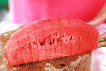 Watermelon fruit sliced pieces on the wooden floor.