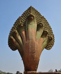 Naga stone statue in front of famous Angkor Wat temple complex,