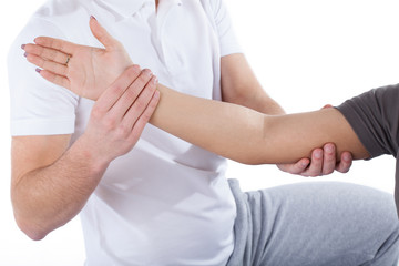 Physiotherapy doctor examining woman's elbow