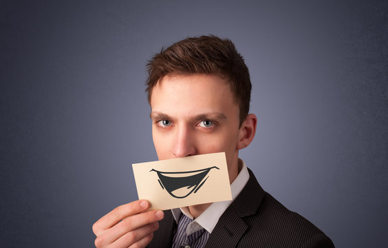 Happy businessman holding funny white card on his mouth