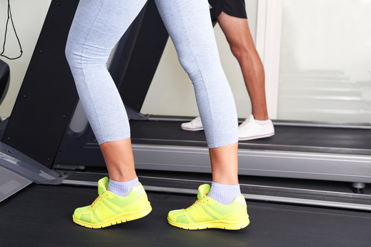 Women and men feet on treadmill close-up