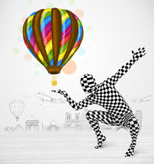 man in full body suit holding balloon