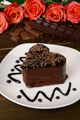 Sweet cake with chocolate on plate on table close-up