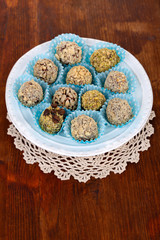 Set of chocolate candies, on plate, on wooden background