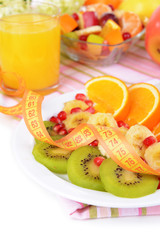 Sweet fresh fruits on plate on table close-up