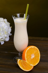 Milk shake on table on dark yellow background