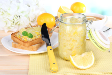 Delicious toasts with lemon jam on plate on table close-up