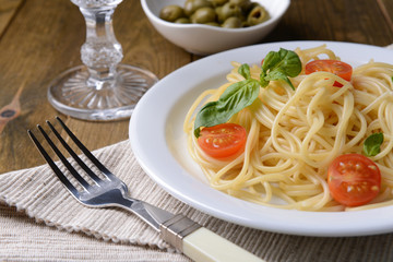 Delicious spaghetti with tomatoes on plate on table close-up