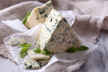 Tasty blue cheese with basil on paper