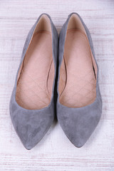 Beautiful grey female shoes on wooden background