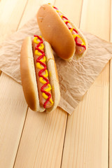 Tasty hot dogs on wooden table