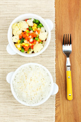 Cooked rice with vegetables on wooden table