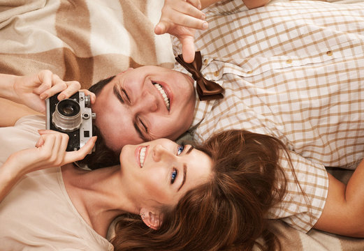 Beautiful vintage style smiling couple lying on the blanket