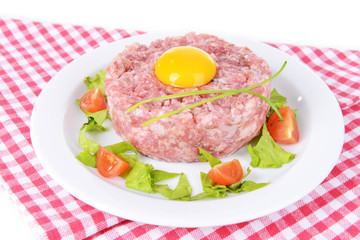 Delicious steak tartare with yolk on plate on table close-up