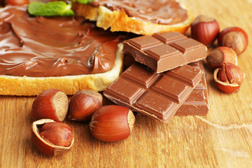 Bread with sweet chocolate hazelnut spread on wooden background