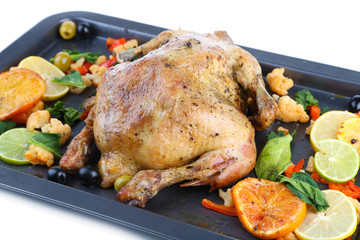 Whole roasted chicken with vegetables on tray, isolated on