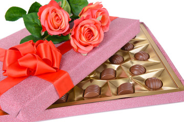 Delicious chocolates in box with flowers close-up